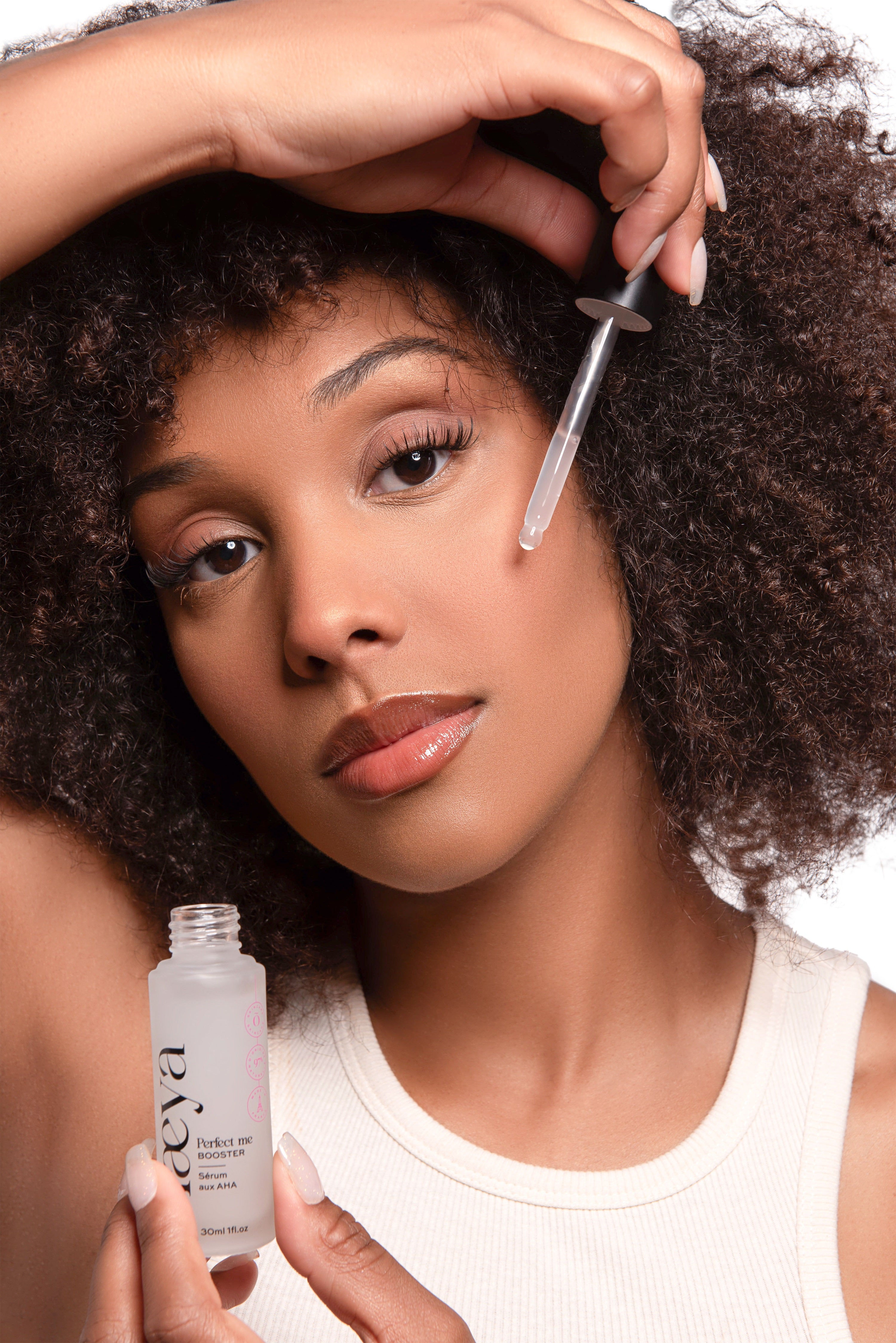 Mannequin tenant le sérum aux AHA Booster Perfect Me Olaeya